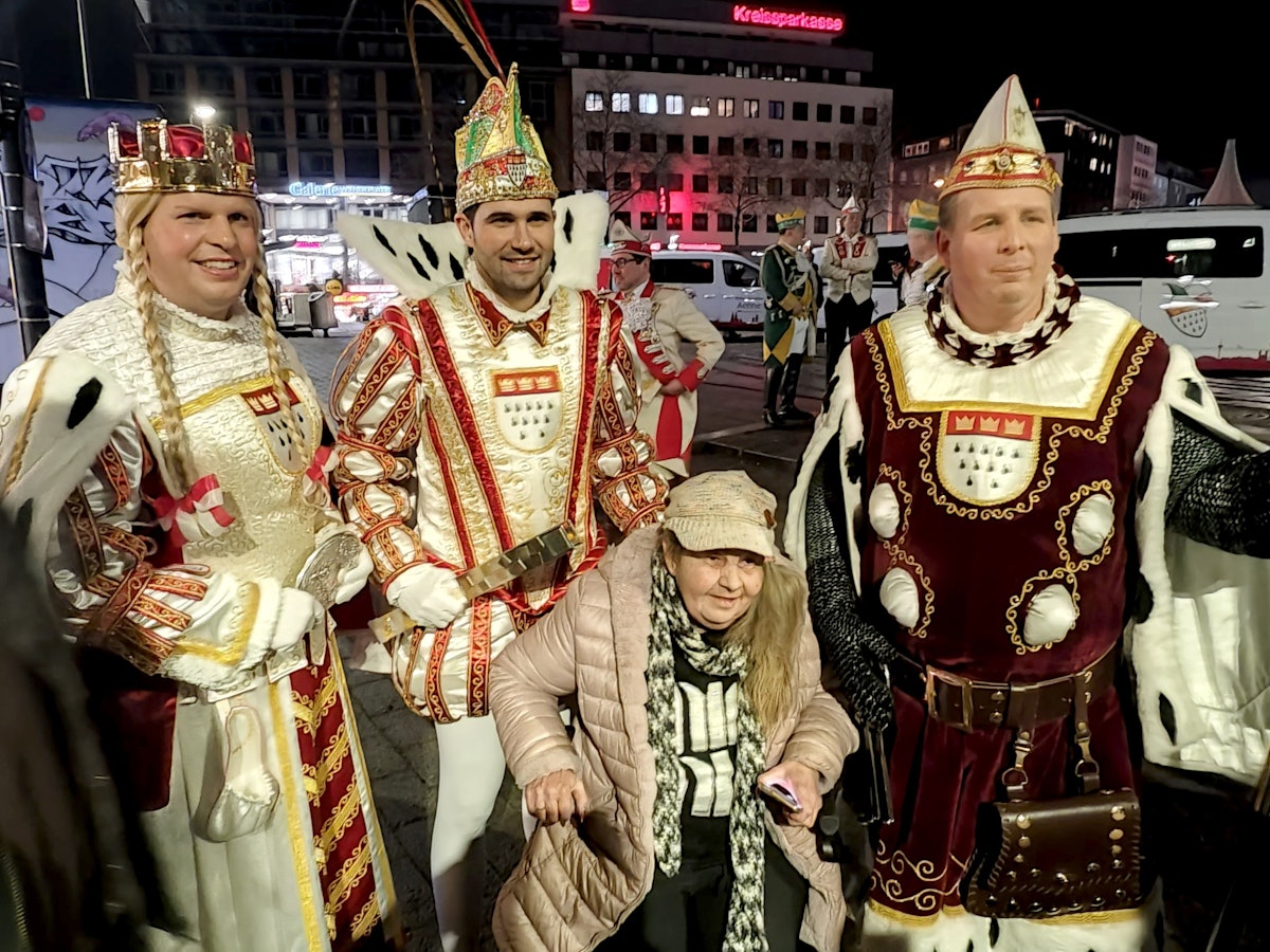 Eine alte Dame posiert mit dem Kölner Dreigestirn.