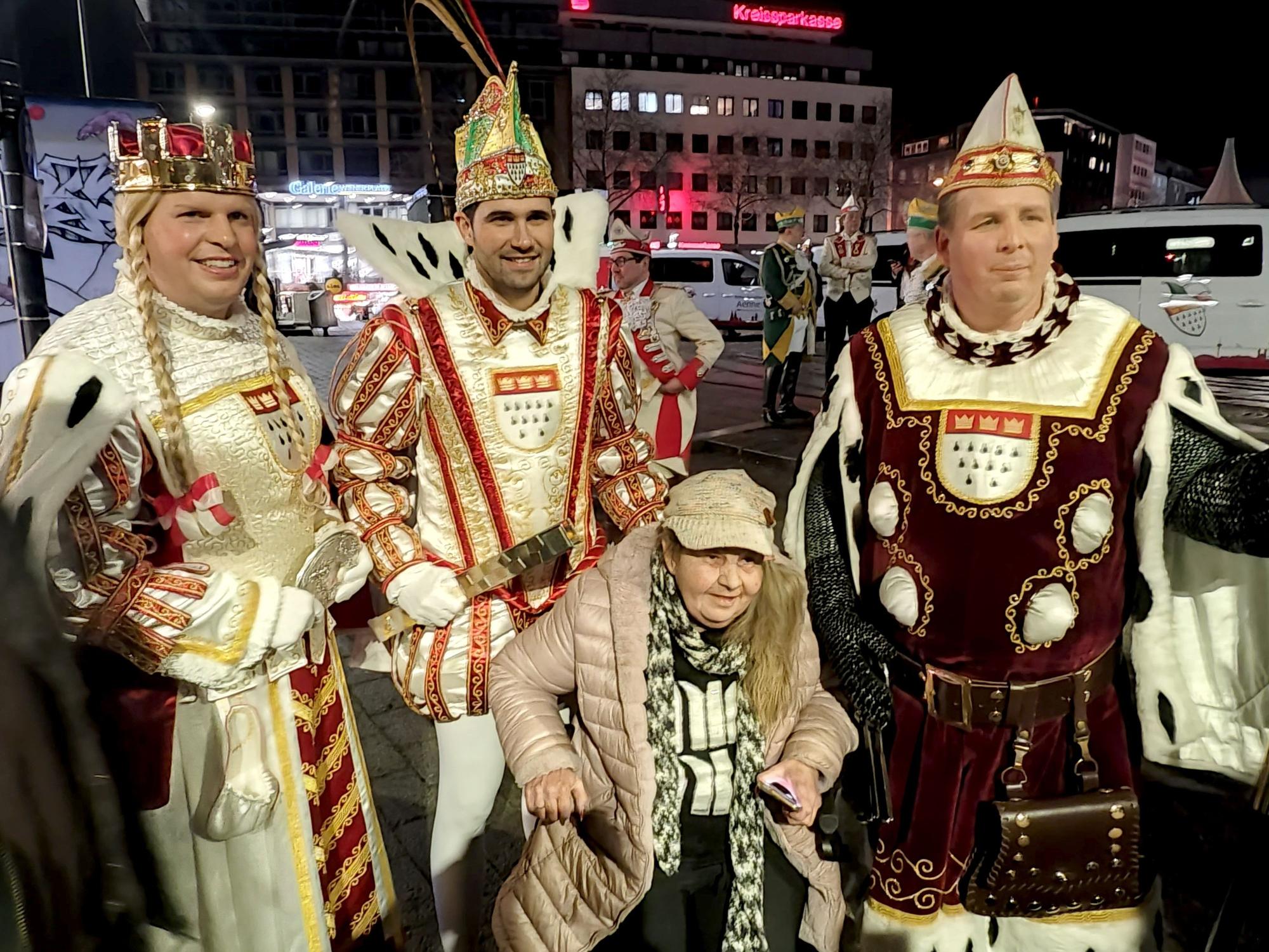 Eine alte Dame posiert mit dem Kölner Dreigestirn.