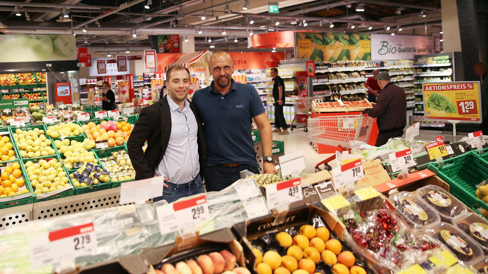 Im Rewe in Hamburg posieren die Inhaber Holger Stanislawski und Alexander Laas in der Gemüseabteilung.