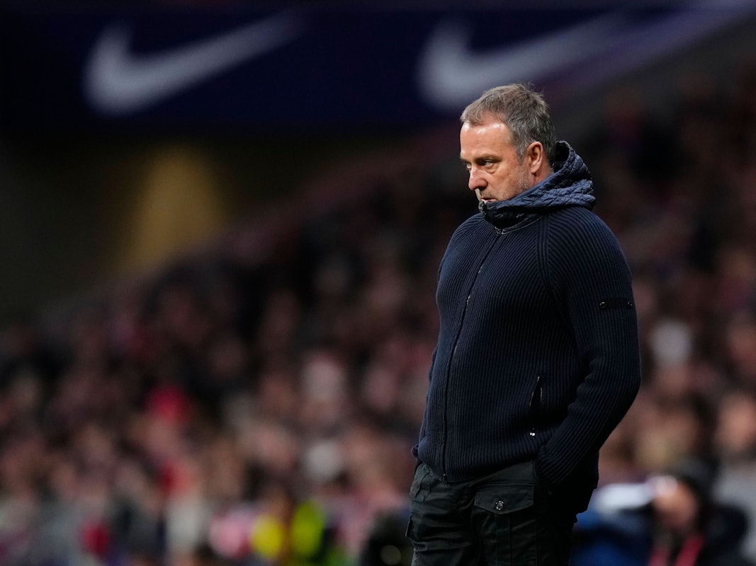 Hansi Flick vergräbt sein Gesicht in seiner Jacke.