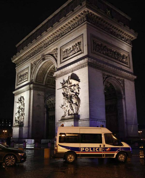 Ein Polizeifahrzeug steht am Triumphbogen in Paris.