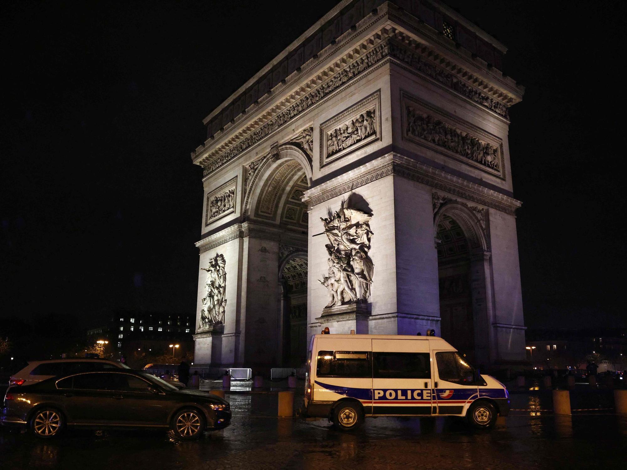 Ein Polizeifahrzeug steht am Triumphbogen in Paris.