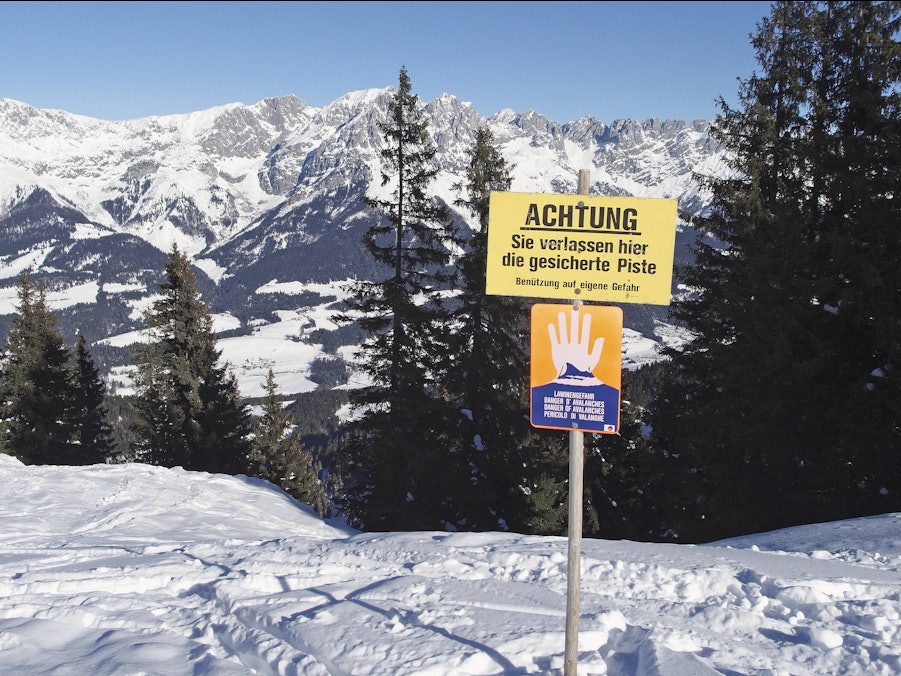 Warnschild in winterlicher Berglandschaft