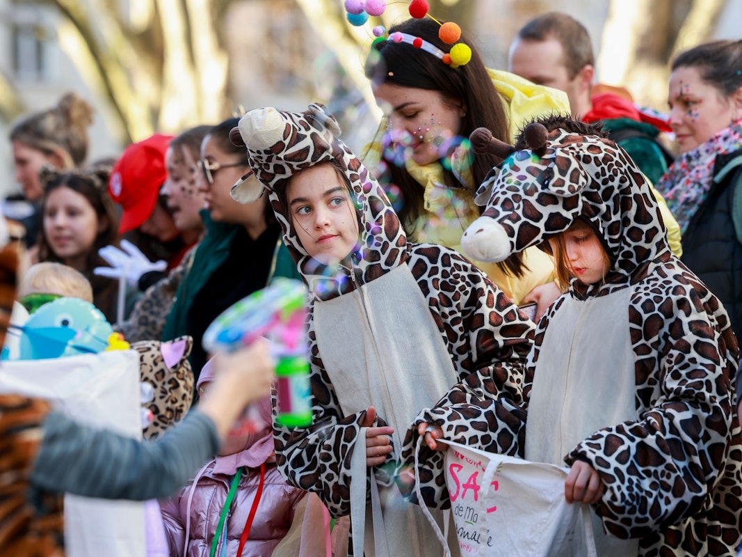 Verkleidete Kinder gehen in einem Karnevalszug mit.