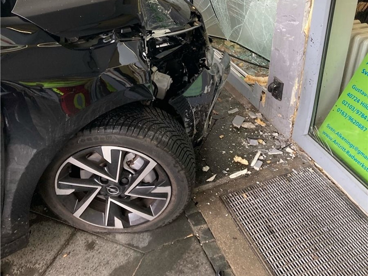Ein Opel Corsa steckt in der zerstörten Glasfront eines Geschäfts.