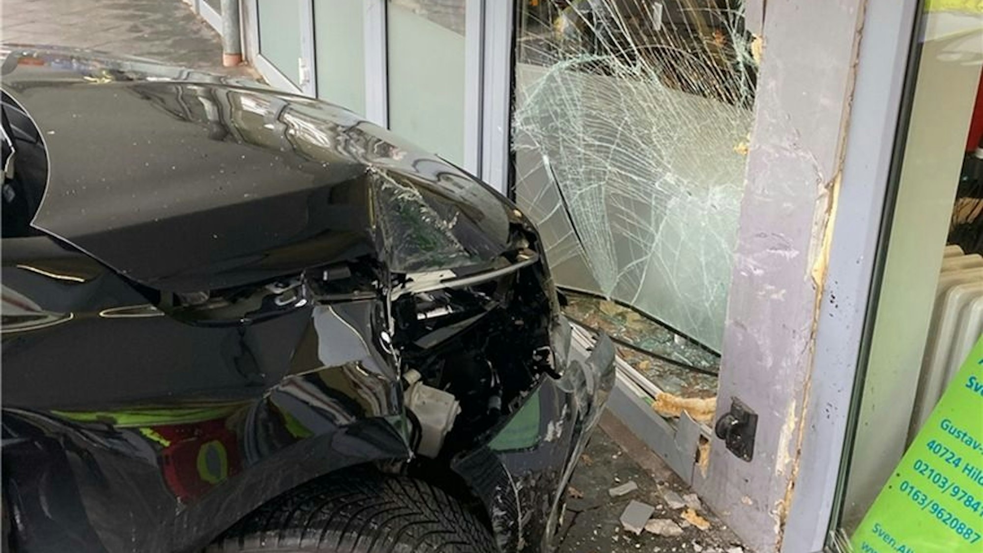 Ein Opel Corsa steckt in der zerstörten Glasfront eines Geschäfts.