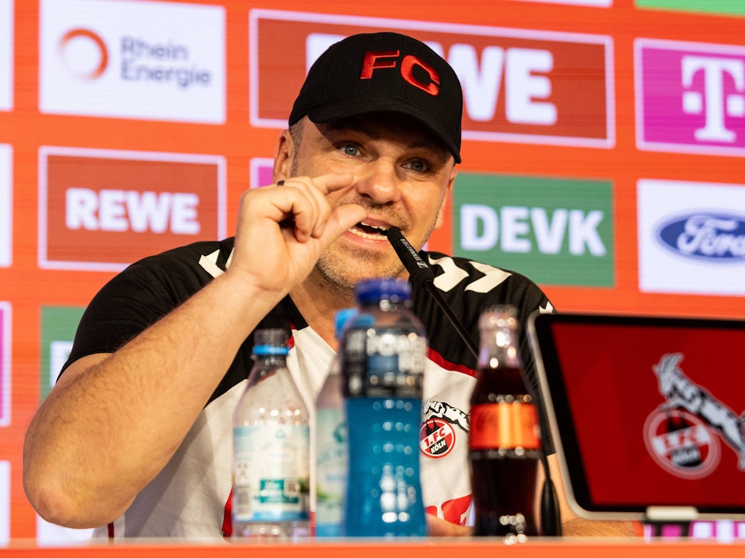 Lukas Kwasniok gestikuliert bei einer Pressekonferenz des 1. FC Köln.