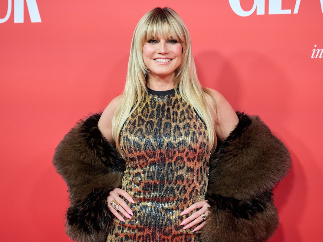 Heidi Klum posiert vor einer Wand.