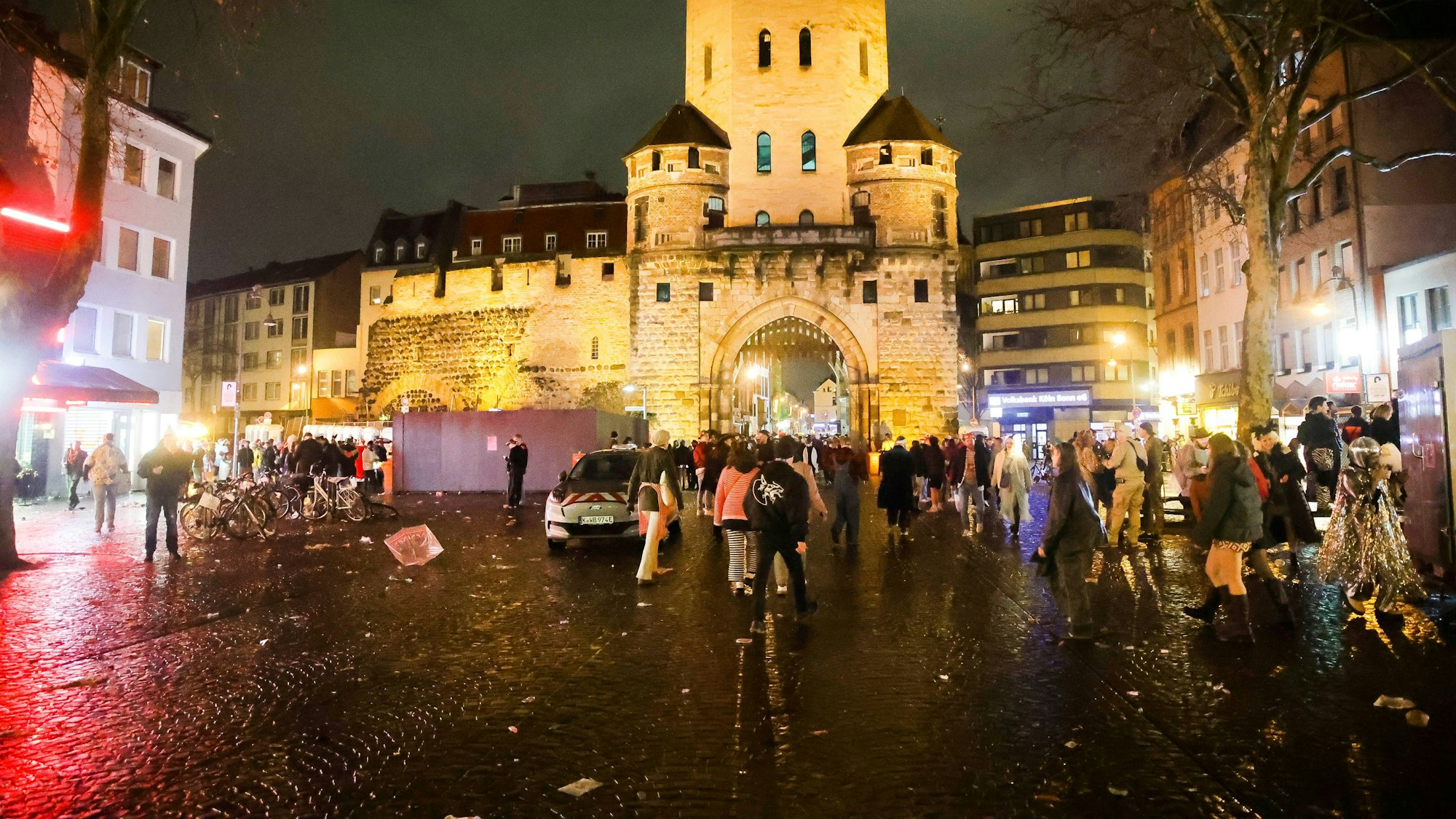Vor einem historischen Burgtor feiern verkleidete Menschen.