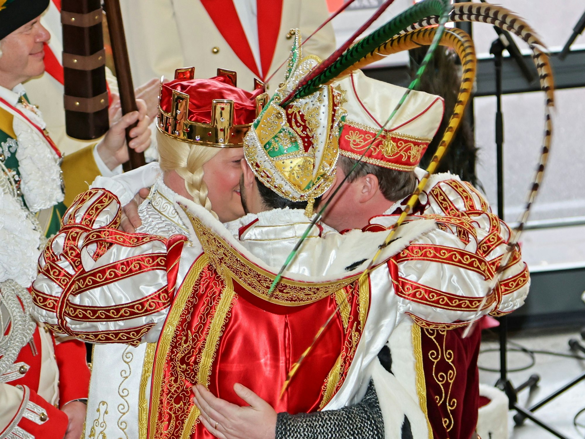Das Kölner Dreigestirn umarmt sich auf der Bühne.