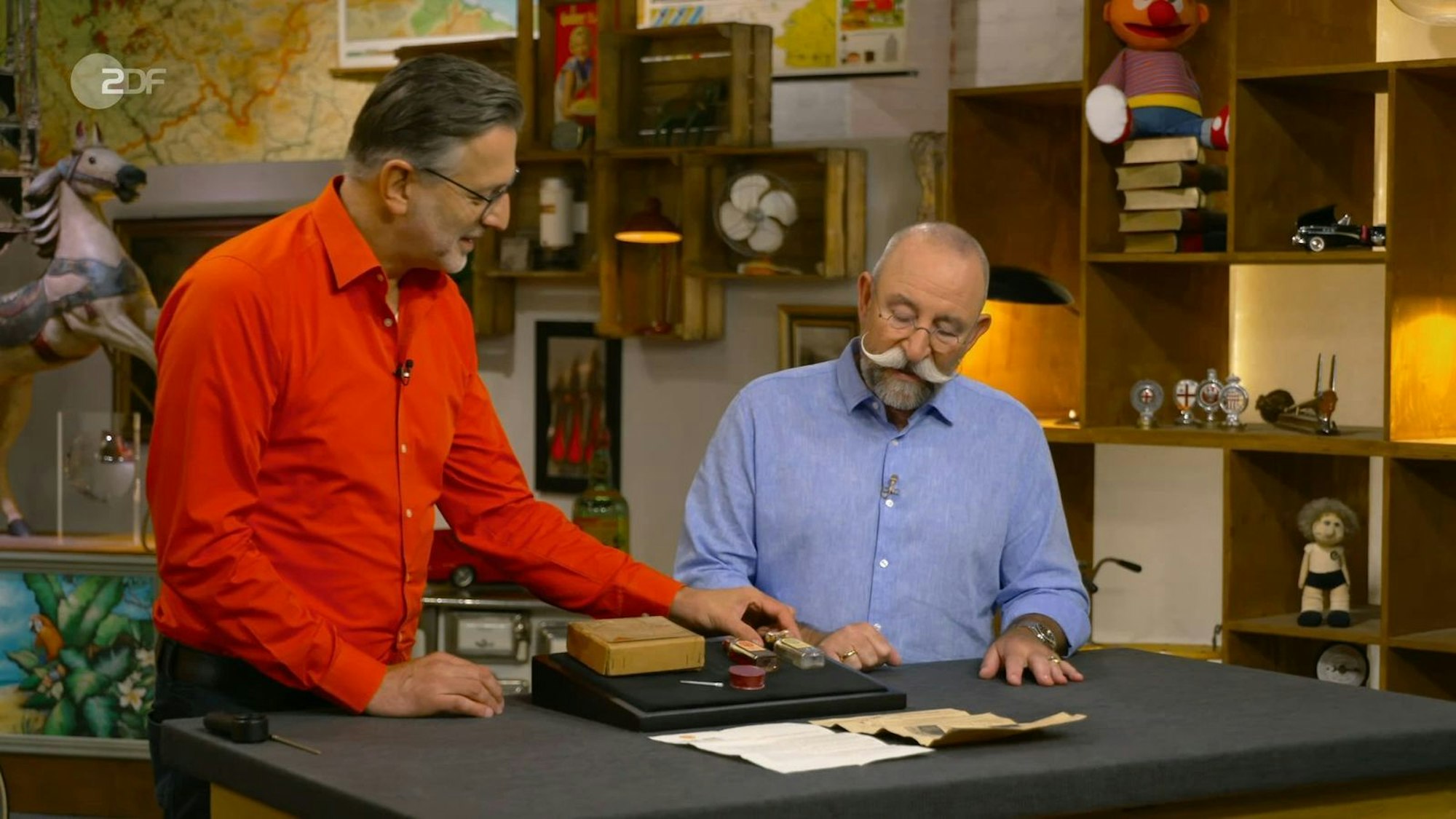„Ich bin gespannt, was es ist“, schaute sich „Bares für Rares“-Moderator Horst Lichter fragend die zwei kleinen Fläschchen an.
(Bild: ZDF)