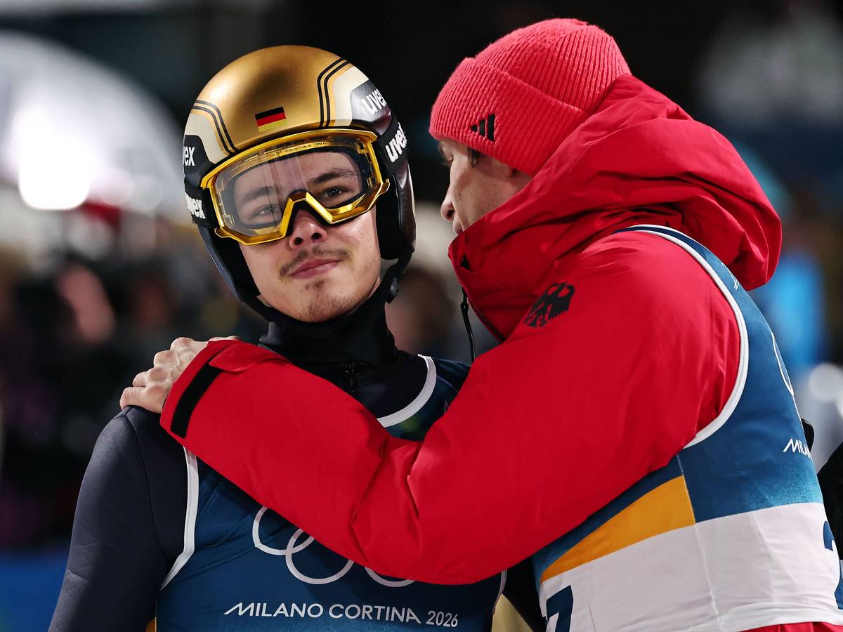 Philipp Raimund wird im Olympia-Wettbewerb im Skispringen von Andreas Wellinger getröstet.