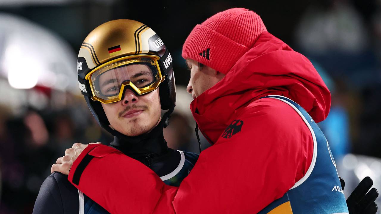 Philipp Raimund wird im Olympia-Wettbewerb im Skispringen von Andreas Wellinger getröstet.