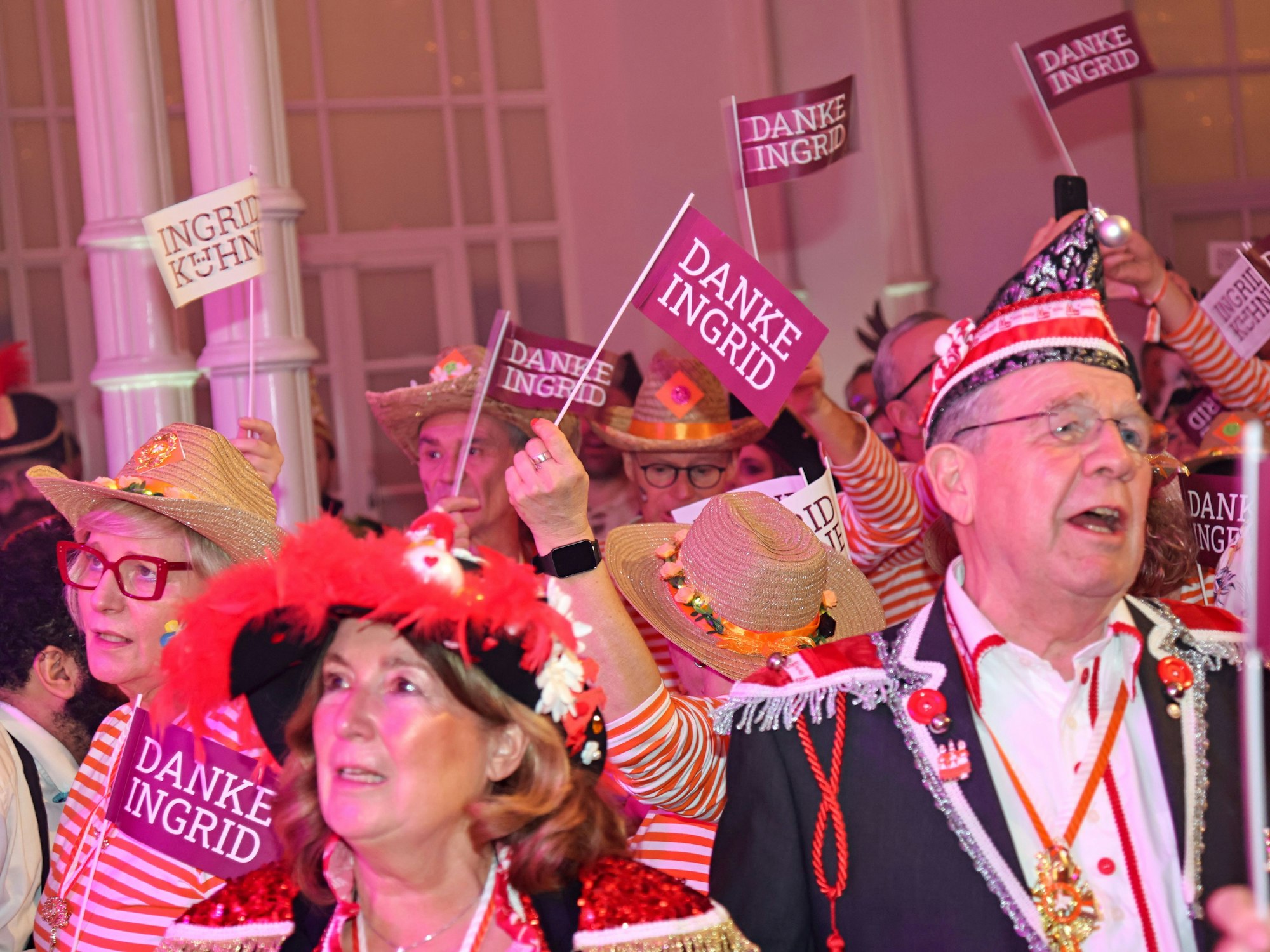Gäste halten „Danke Ingrid“-Fähnchen in die Luft.