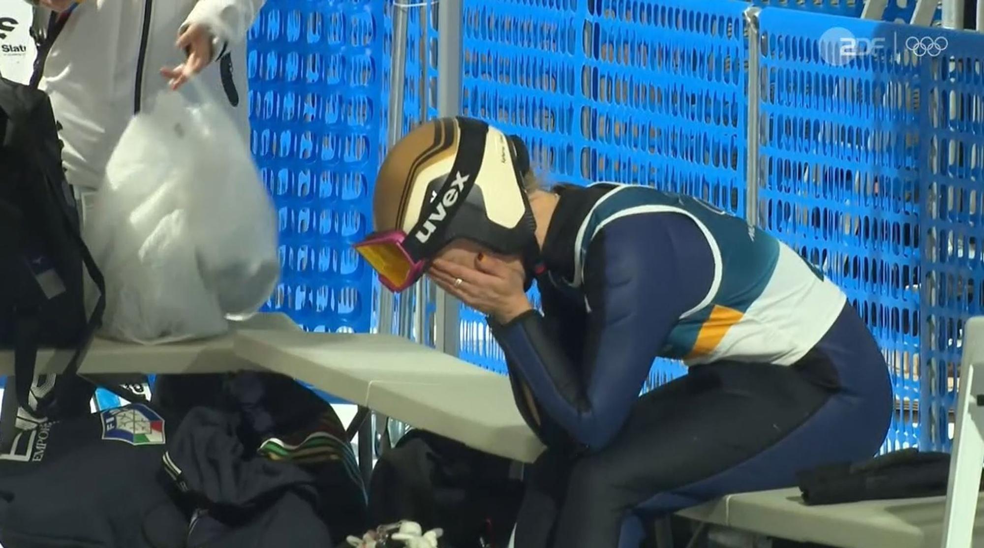 Katharina Schmid hat ihr Gesicht in den Händen vergraben.