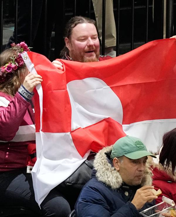 Fans halten die Nationalflagge Grönlands in die Höhe.