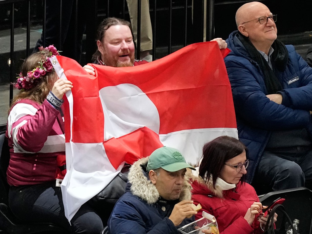 Fans halten die Nationalflagge Grönlands in die Höhe.