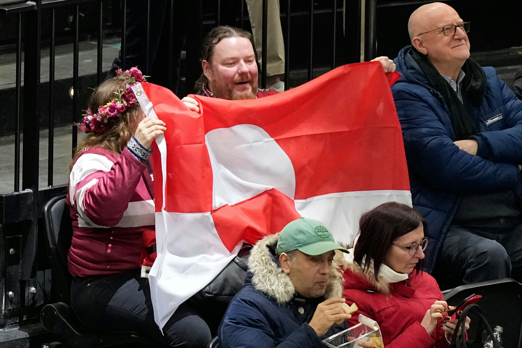 Fans halten die Nationalflagge Grönlands in die Höhe.