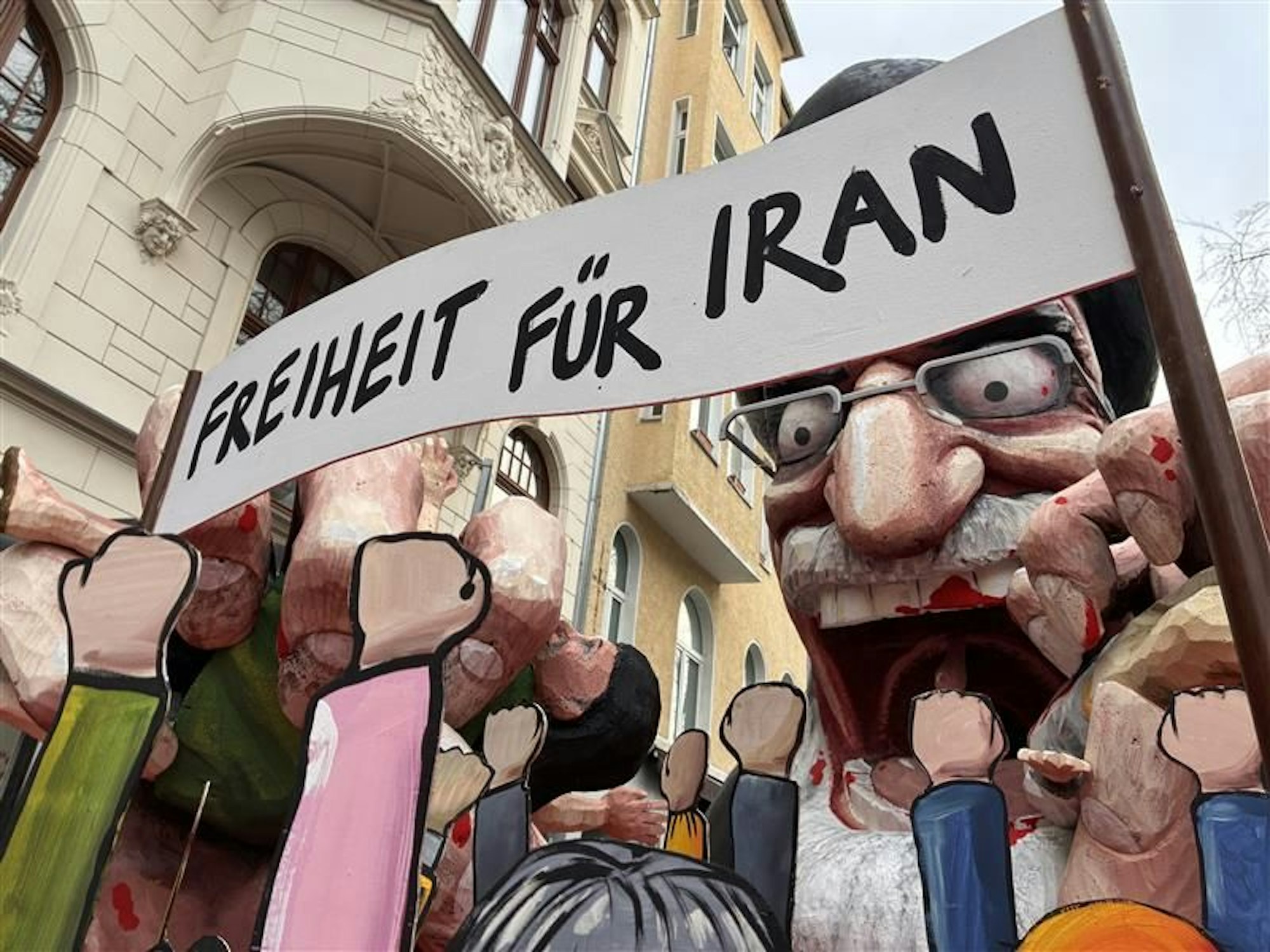 Bis zuletzt wurde der Persiflagewagen geheim gehalten. Er zeigt den iranischen Religionsführer Ali Chamenei, der sein Volk verspeist.