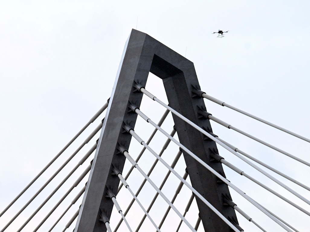 Eine Drohne steigt neben den Drahtseilen der Leverkusener Rheinbrücke auf, um den Zustand der Konstruktion zu überprüfen. Die Autobahnmeisterei sperrte die Autobahn 1 (A1) in beide Richtungen, nachdem sich über Nacht Eis gebildet hatte, das auf darunter fahrende Fahrzeuge hätte stürzen können.