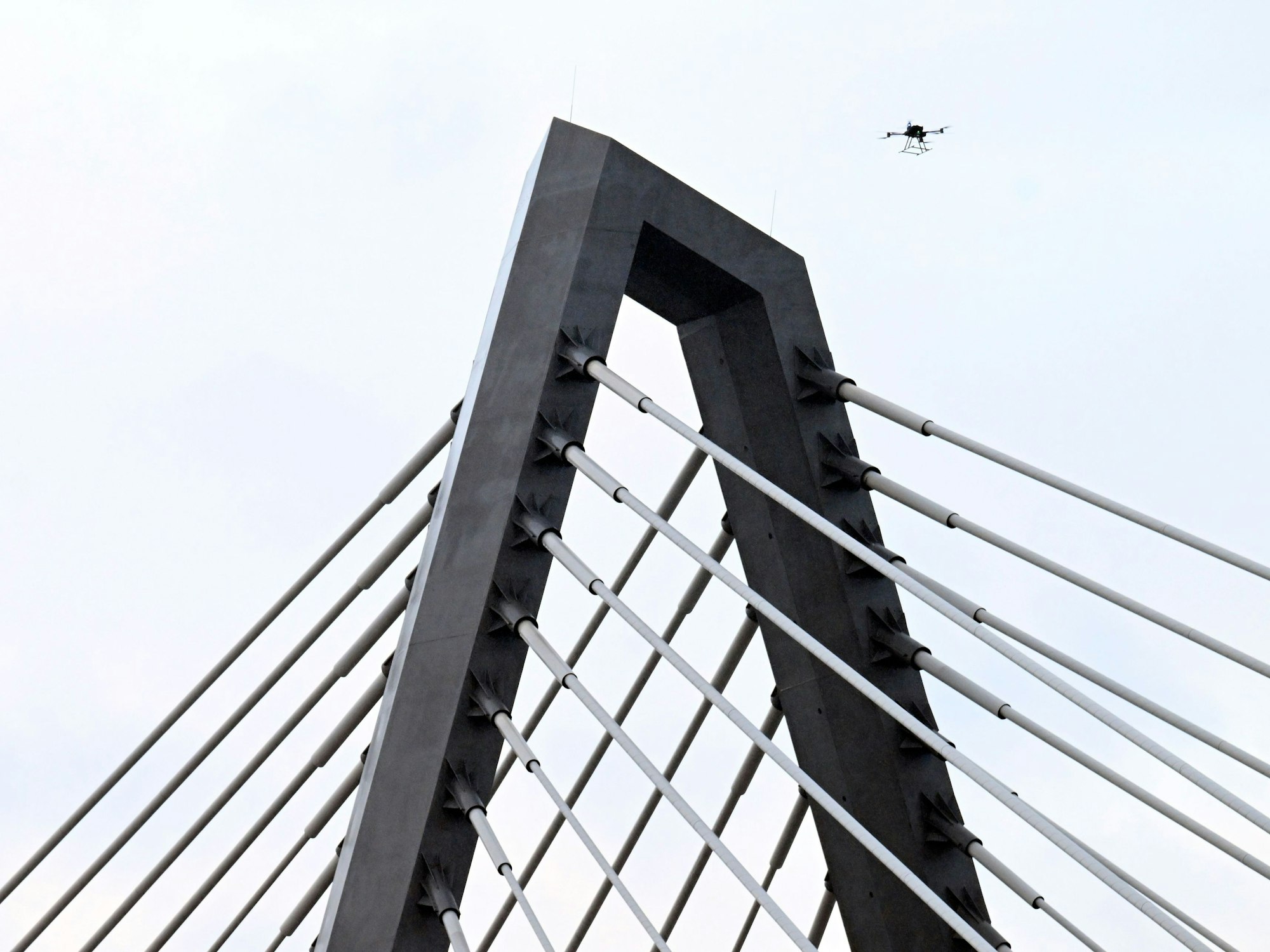 Eine Drohne steigt neben den Drahtseilen der Leverkusener Rheinbrücke auf, um den Zustand der Konstruktion zu überprüfen. Die Autobahnmeisterei sperrte die Autobahn 1 (A1) in beide Richtungen, nachdem sich über Nacht Eis gebildet hatte, das auf darunter fahrende Fahrzeuge hätte stürzen können.