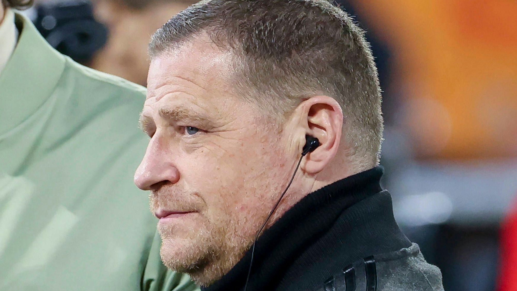 Max Eberl wird interviewt und hat Kopfhörer an.