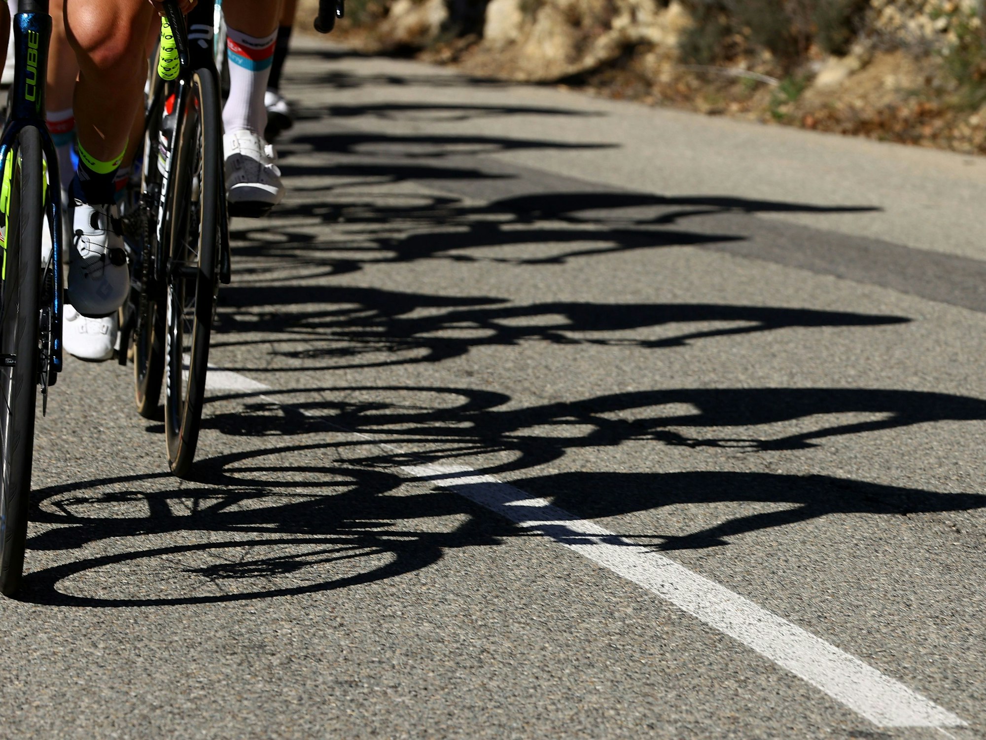 Die Schatten eines Fahrerfeldes im Radsport.