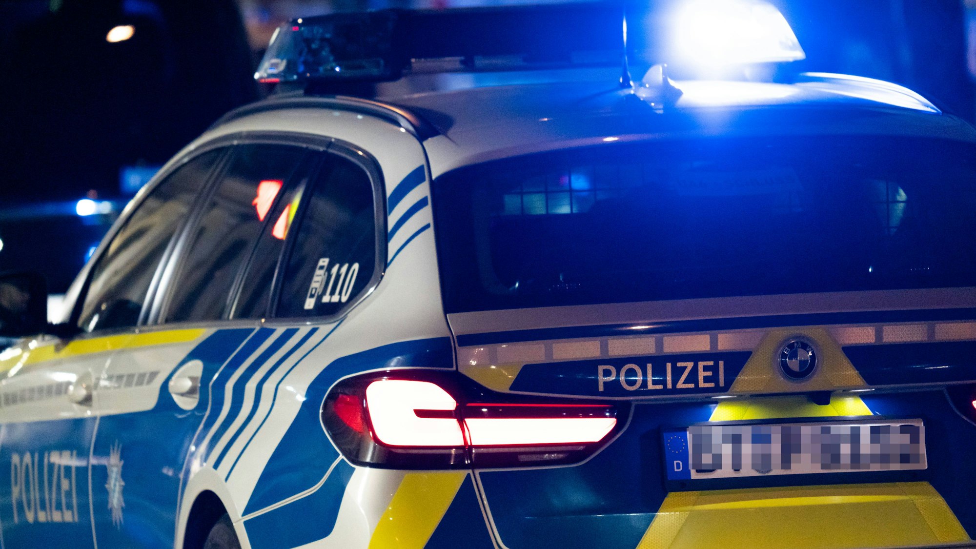 Polizeistreifenwagen mit Blaulicht bei Nachteinsatz