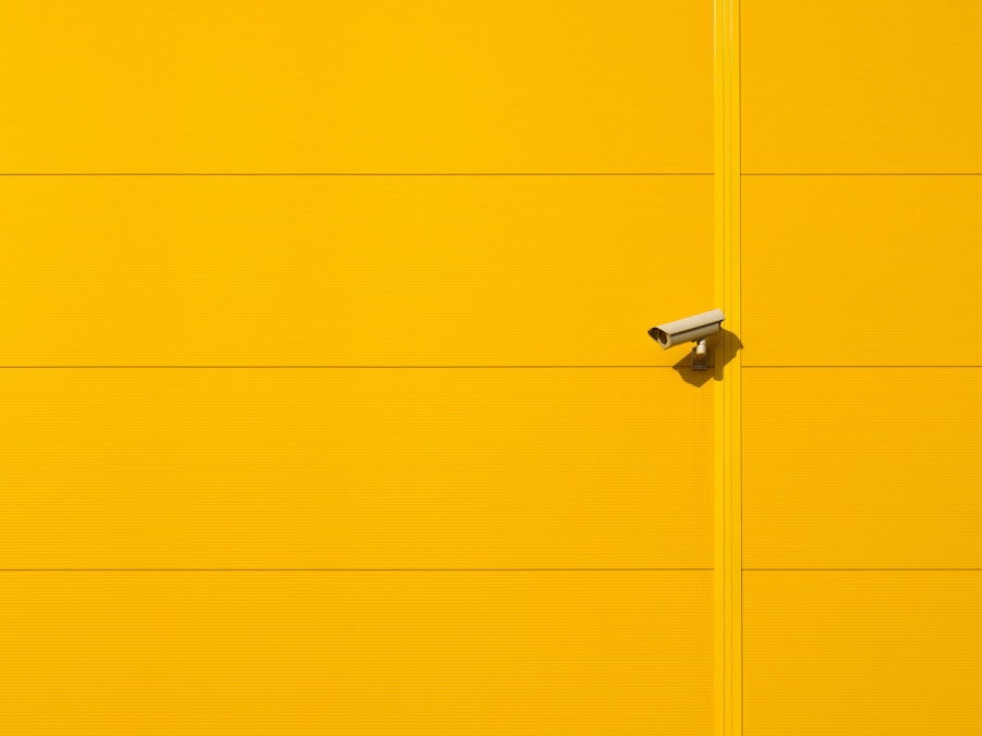 Überwachungskamera und gelbe Wand