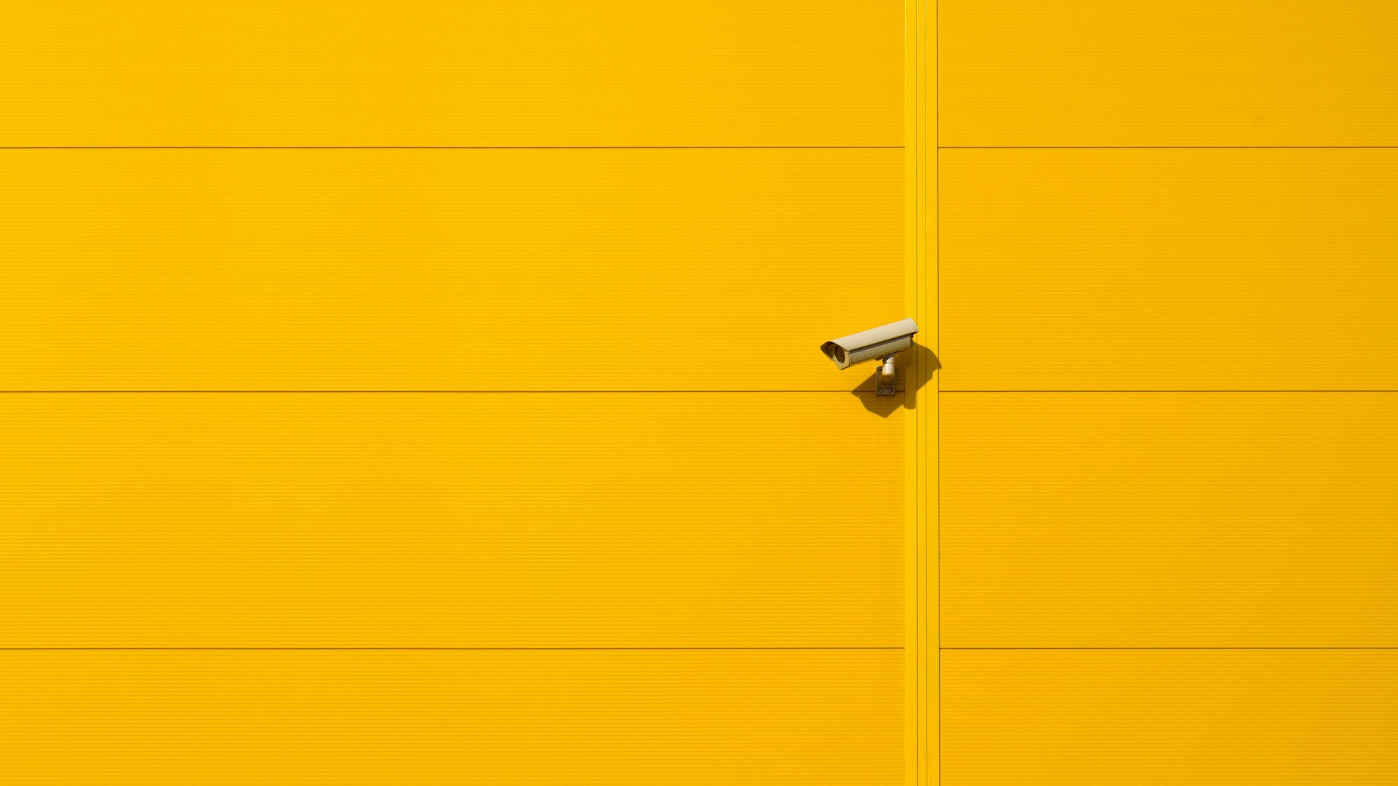 Überwachungskamera und gelbe Wand
