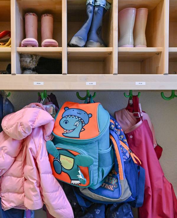Kleidung von Kindern hängt in einer Kita.