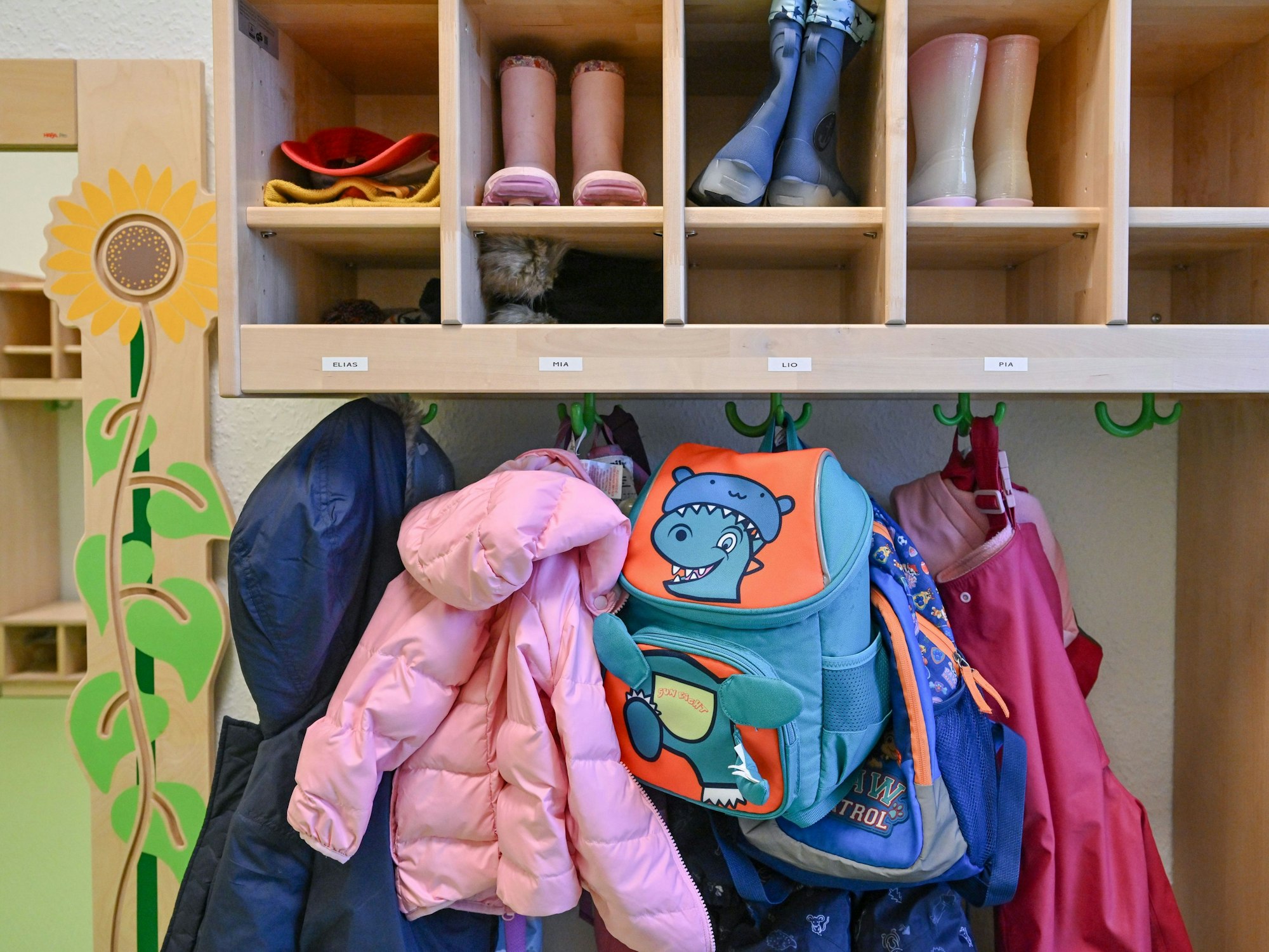 Kleidung von Kindern hängt in einer Kita.