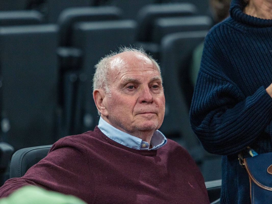 Uli Hoeneß sitzt bei einem Spiel des FC Bayern München auf der Tribüne.