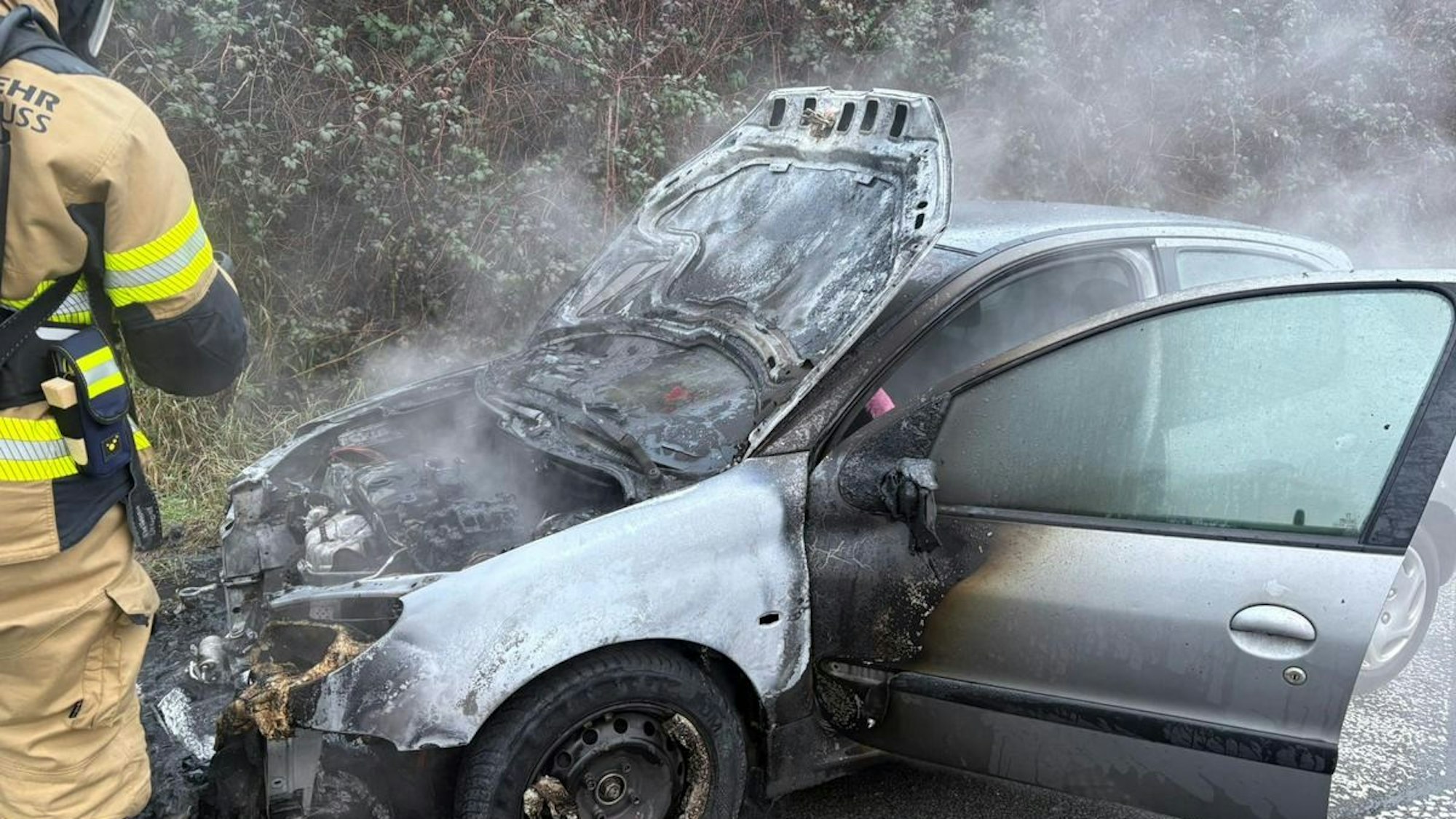 Ein ausgebrannter Pkw steht auf dem Standstreifen der Autobahn.