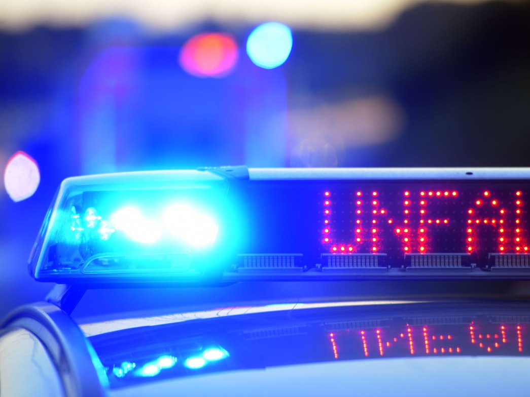 Auf einem Polizeifahrzeug warnt auf der Autobahn eine Leuchtschrift vor einer Unfallstelle.