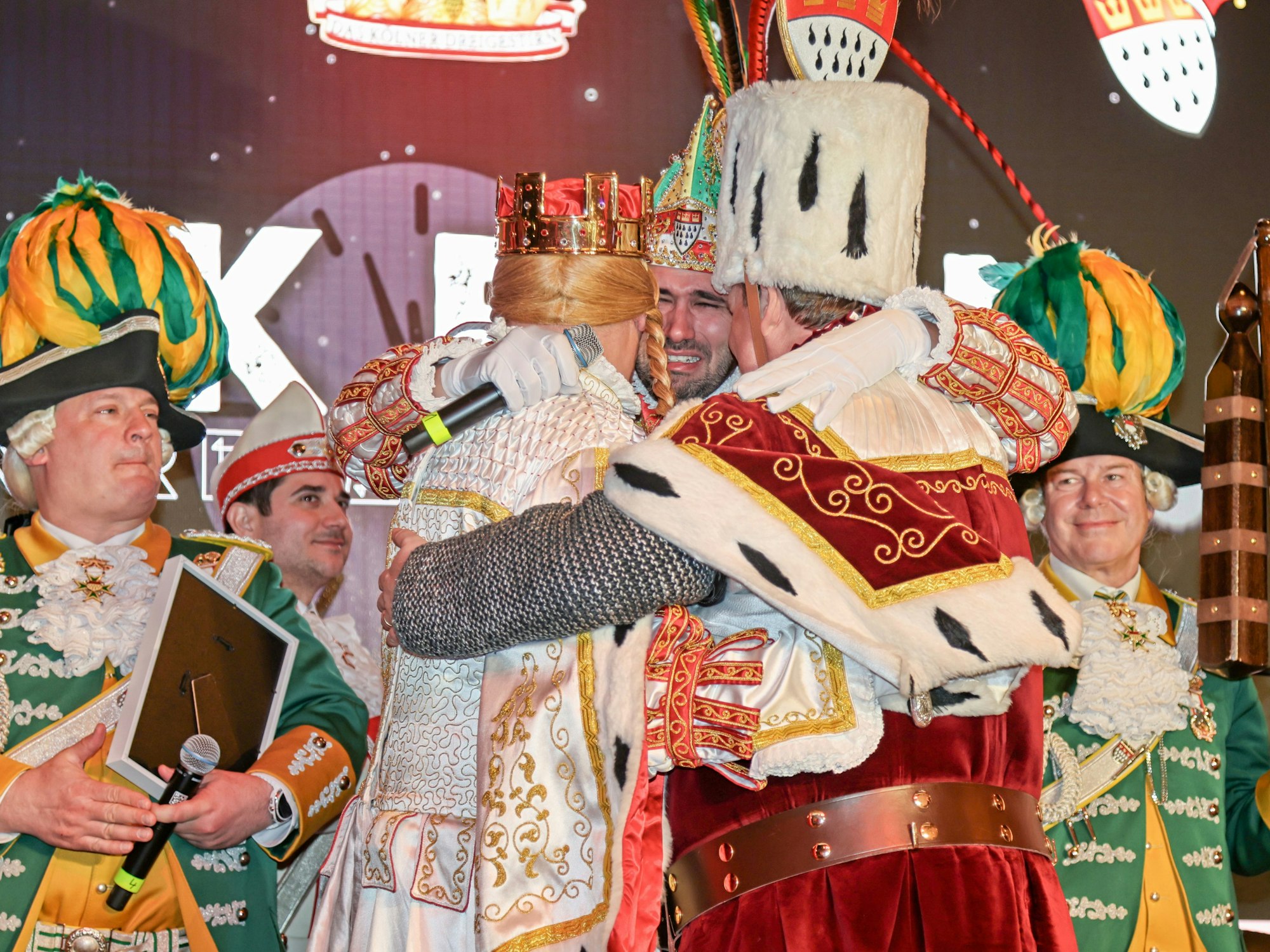 Das Dreigestirn liegt sich weinend in den Armen.