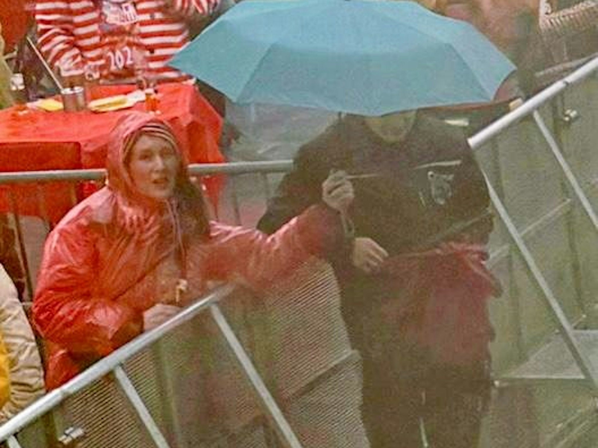 Eine Frau hält einen Regenschirm über einen Techniker.