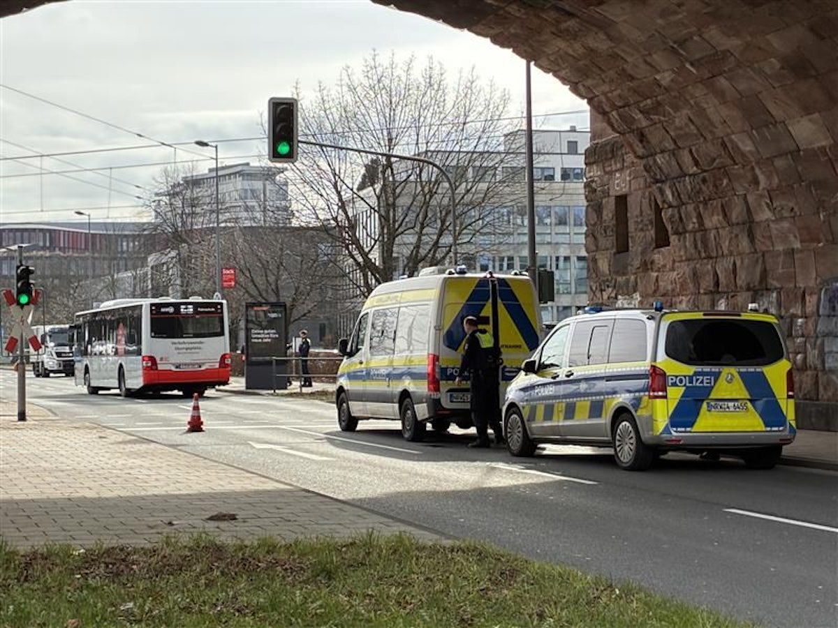 Zwei Polizeiwagen stehen hinter einem Bus.