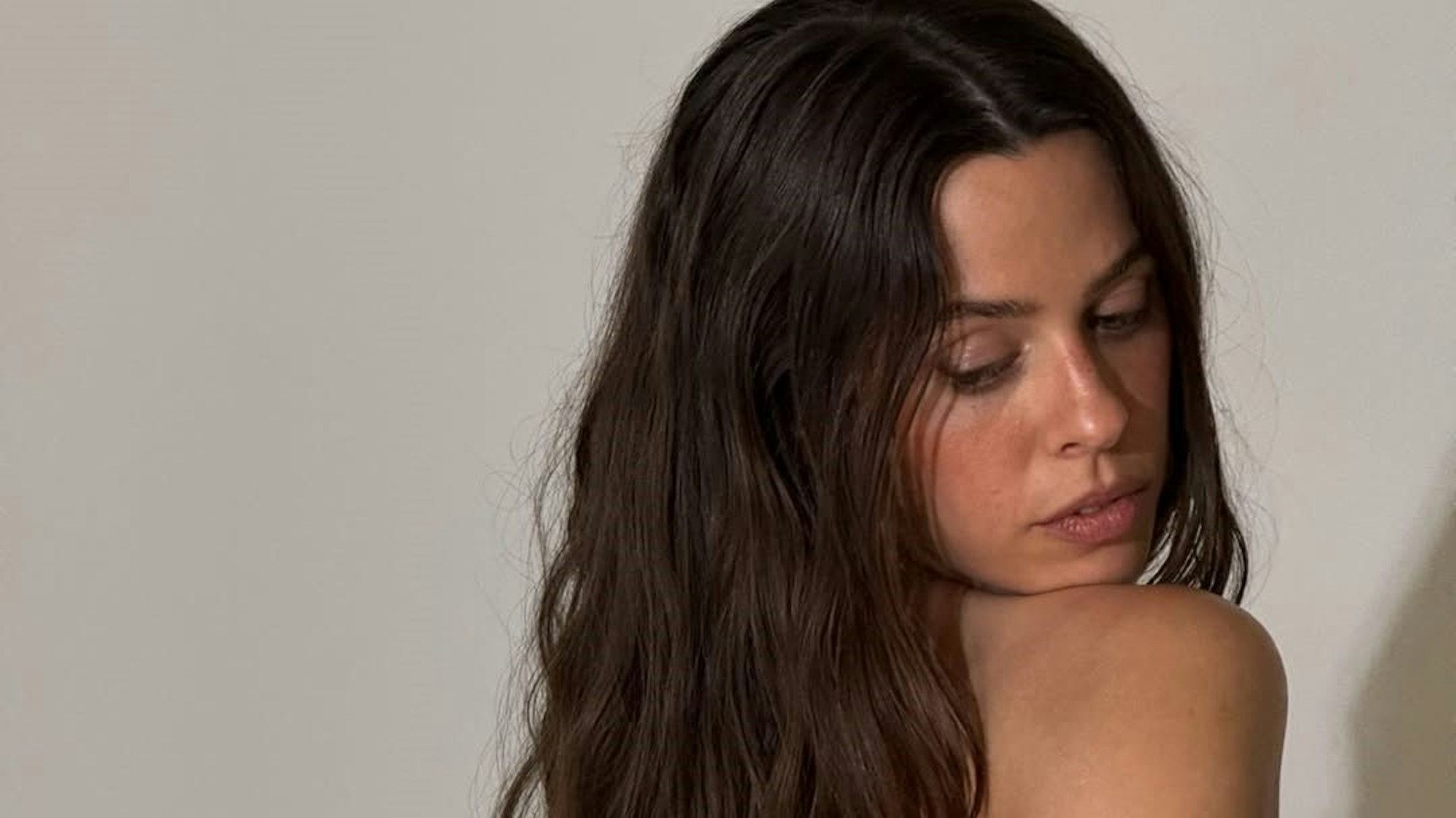 Vanessa Mai schaut seitlich an sich herunter.