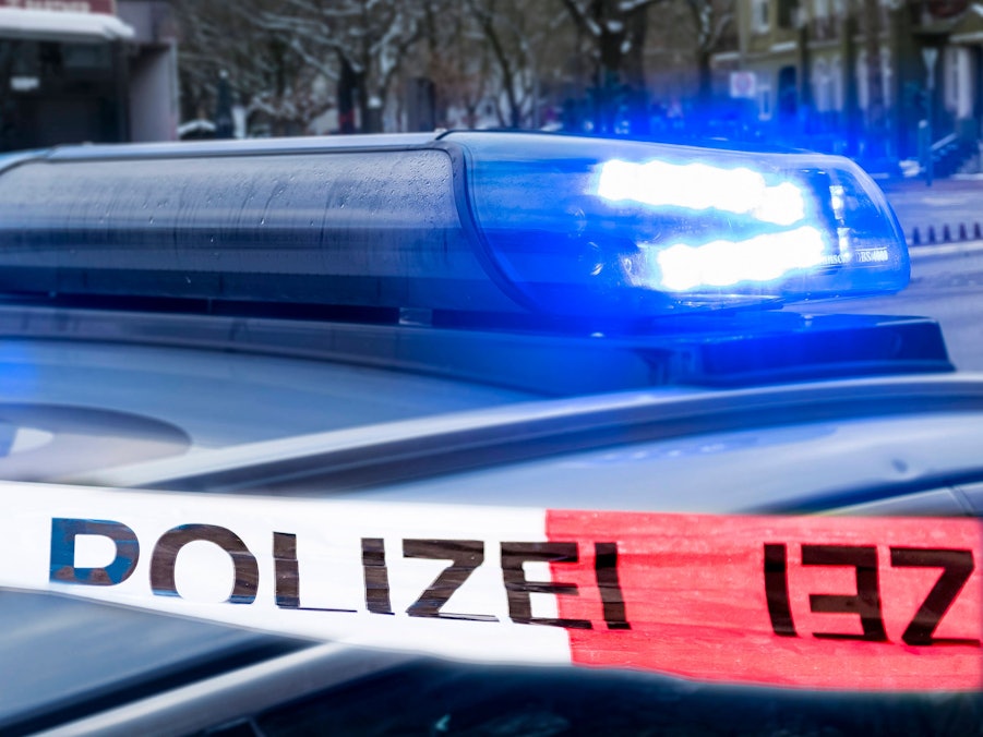 Polizeiauto mit Blaulicht und Polizeiband