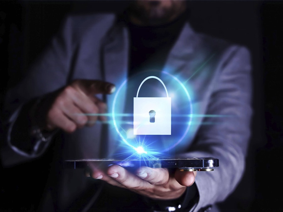 Geschäftsmann mit Smartphone und Sicherheitssymbol