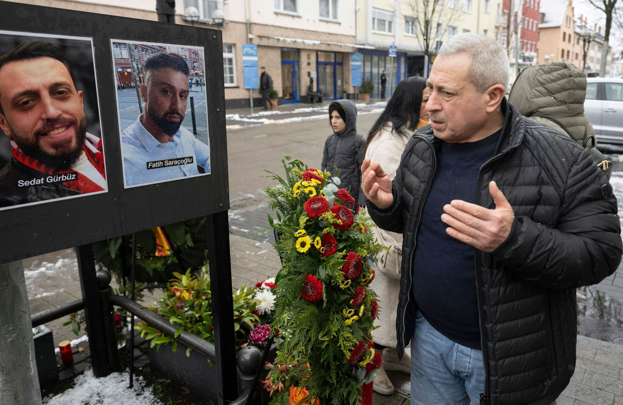 Selahattin Gürbüz betet am damaligen Tatort am Heumarkt in Hanau neben Fotos der Getöteten während eines stillen Gedenkens für die Opfer des rassistischen Anschlages von Hanau.