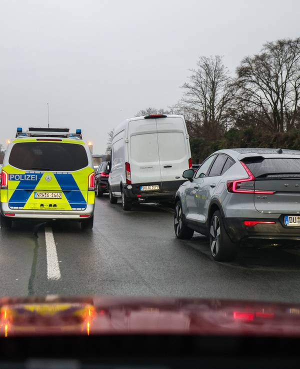 Polizeibeamte fahren mit ihrem Fahrzeug durch die Rettungsgasse nach einem Schadensereignis.