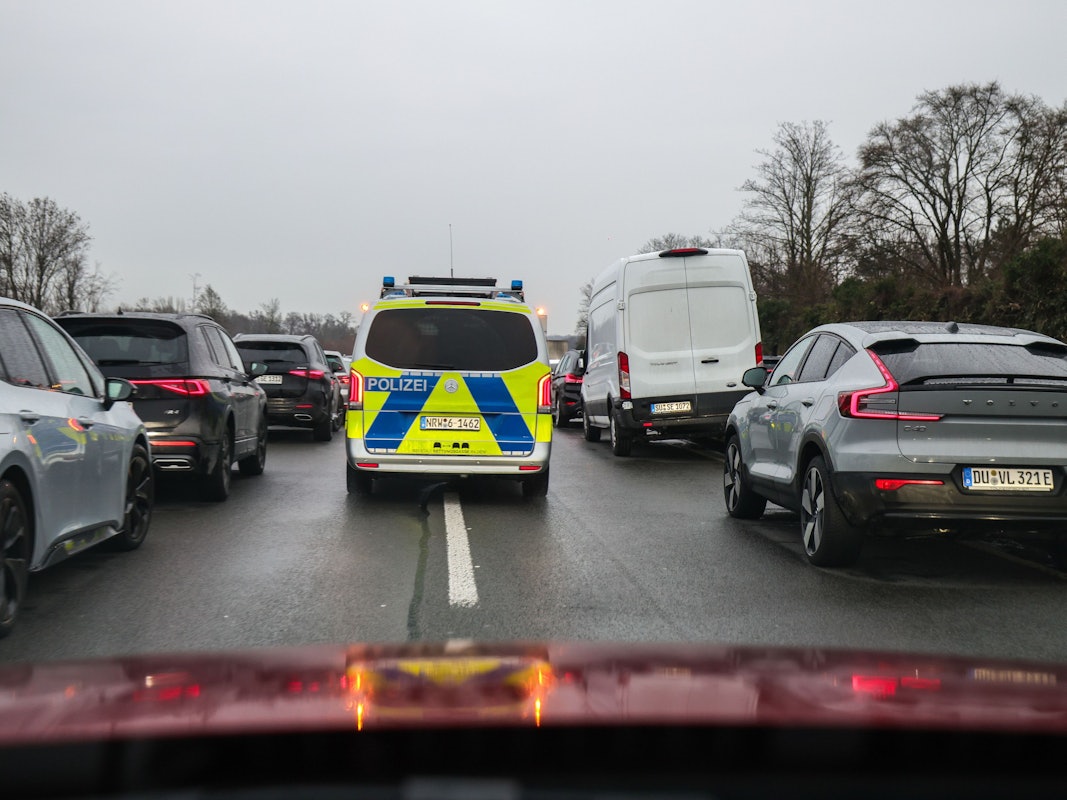 Polizeibeamte fahren mit ihrem Fahrzeug durch die Rettungsgasse nach einem Schadensereignis.