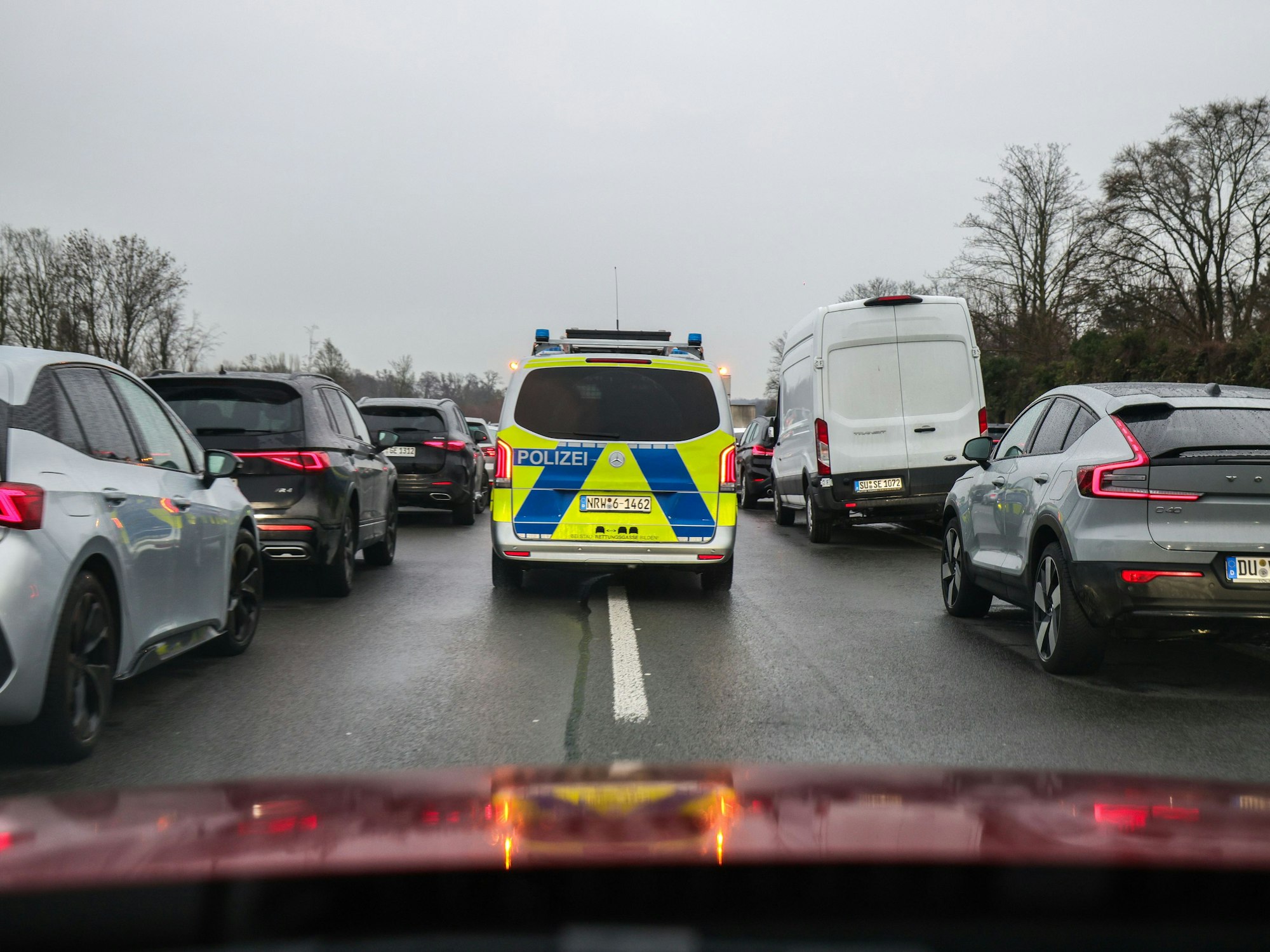Polizeibeamte fahren mit ihrem Fahrzeug durch die Rettungsgasse nach einem Schadensereignis.