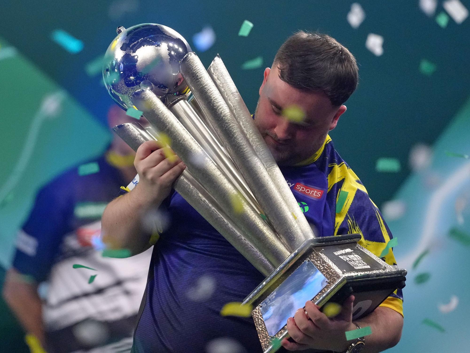 Der Engländer Luke Littler hebt die Trophäe nach seinem Sieg.