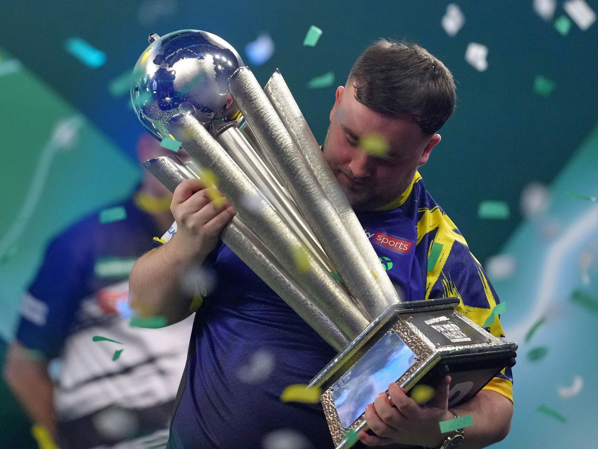 Der Engländer Luke Littler hebt die Trophäe nach seinem Sieg.