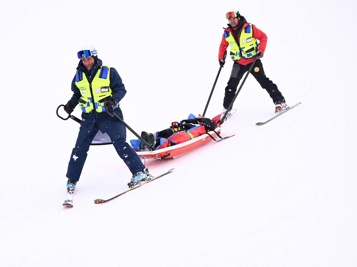 Medizinisches Personal transportiert den verunglückten Skifahrer auf einer Liege ab.