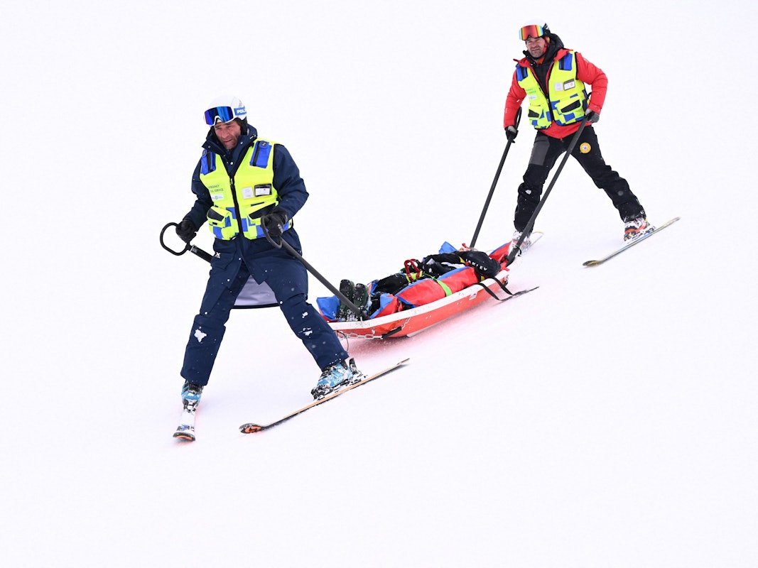 Medizinisches Personal transportiert den verunglückten Skifahrer auf einer Liege ab.