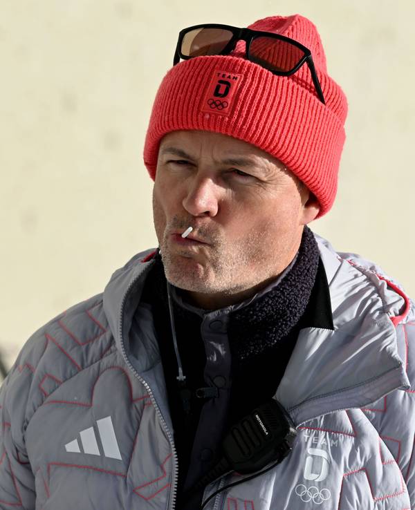 Sportdirektor Felix Bitterling mit einem Lutscher im Mund in der Anterselva Biathlon Arena.